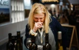 L'acheteuse de vin britannique Liz Donnelly prend des notes sur les différentes bouteilles de la Cave de Gan-Jurançon lors du salon Wine Paris et Vinexpo Paris la Porte de Versailles, le 13 février 2024 à Paris
