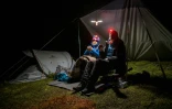 Aliki Buhayer-Mach et son mari François, bénévoles de l'ONG Oppal pour la protection des alpages, surveillent un troupeau de moutons, le  9 août 2023 à Pontimia, dans les Alpes suisses