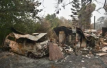 Une maison et une camionnette brûlés gisent dans la ville de Bilpin, à l'ouest de Sydney, le 29 décembre 2019