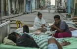 Plusieurs familles passent la nuit sur des lits installés dans la rue, dans un quartier central de La Havane, le 30 juillet 2026, après l'effondrement partiel de leur immeuble