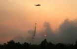Un hélicoptère largue de l'eau sur des forêts et des terres en feu dans la région de Petuk Katimpun, à Palangkaraya, dans la province du Kalimantan central, en Indonésie, le 13 août 2026

A helicopter drops water on burning forests and land in the Petuk Katimpun area, Palangkaraya, in Indonesia's Central Kalimantan province, on August 13, 2026.