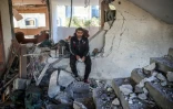 Un homme est assis dans un bâtiment lourdement endommagé suite à une frappe à Deir el-Balah dans le centre de la bande de Gaza, le 15 novembre 2024