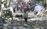 Une fillette marche le 8 juin 2024 dans des gravats de bâtiments détruits lors d'une opération israélienne pour libérer des otages à Nousseirat, dans le centre de la bande de Gaza, où une guerre oppose Israël au mouvement islamiste Hamas