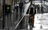 Une cycliste et des piétons à Bordeaux au lendemain de l'obligation de porter à nouveau le masque dans les rues de la ville, le 27 novembre 2021