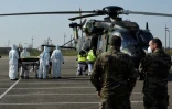 Des équipes médicales transportent un patient contaminé par le Covid-19 pour l'évacuer à bord d'un hélicoptère vers l'hôpital d'Essen, en Allemagne, le 28 mars 2020 sur le parking du CHR de Metz