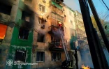 Photo diffusée par le service d'urgence ukrainien le 25 avril 2025, de sauveteurs ukrainiens évacuant une femme d'un immeuble en feu après une attaque de drone à Pavlograd, dans la région de Dnipropetrovsk