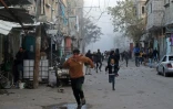 Des Palestiniens courent pour se mettre à l'abri pendant un bombardement, à Bureij, dans le centre de la bande de Gaza, le 12 janvier 2025