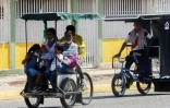 Une famille à bord d'un vélo-taxi le 29 juillet 2021 à Maracaibo, au Venezuela