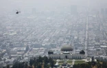 Un hélicoptère survole l'observatoire Griffith à Los Angeles, Californie, alors qu&rsquo;un nuage de pollution opacifie la ville, le 5 juillet 2019