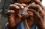 Un toxicomane s'apprête à s'injecter une dose d'héroïne, dans le centre de Medellin, en Colombie, le 17 mars 2022