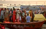 Des pèlerins hindous à bord d'une barque en bois lors du pèlerinage de la Kumbh Mela à Prayagraj, le 31 janvier 2025 en Inde