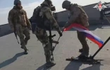 Sur cette image non datée extraite d'une vidéo publiée par le ministère russe de la Défense le 24 février 2024, des soldats russes placent un drapeau national russe sur le toit d'une usine, à Avdiivka, en Ukraine