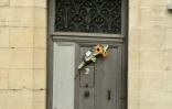 Un bouquet de fleurs sur la porte du domicile de l'homme mortellement agressé lors des fêtes de Bayonne, le 4 août 2023 