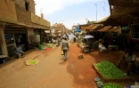 Des Soudanais marchent à travers le marché central de Khartoum, le 10 juin 2019  
