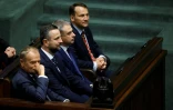 Le Premier ministre polonais Donald Tusk (g) et ses adjoints (2e de gauche à droite), le ministre de la Défense Wladyslaw Kosiniak-Kamysz, le ministre des Affaires numériques Krzysztof Gawkowski et le ministre des Affaires étrangères Radoslaw Sikorski, au parlement polonais, à Varsovie, le 6 août 2025