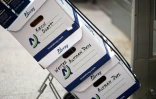 Des cartons de documents juridiques acheminés au palais de justice fédéral d'Oakland pour le procès intenté par Elon Musk contre OpenAI, le 12 mai 2026 en Californie