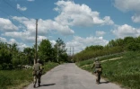 Des soldats ukrainiens patrouillent sur une route de Sydorovié (est de l'Ukraine), le 17 mai 2022