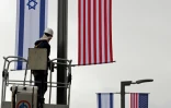 Un homme installe le 7 mai 2018 les drapeaux israélien et américain devant le consulat américain à Jérusalem où les Etats-Unis vont déménager leur ambassade