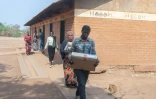 Des membres de la Commission électorale transportent du matériel de vote au centre de vote de l'école primaire de Kalambo à Lilongwe, le 15 septembre 2025 au Malawi