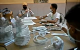 Des bénévoles fabriquent des visières de protection contre le Covid-19 dans un ancien atelier de couture, le 28 octobre 2020 à Caracas, au Venezuela