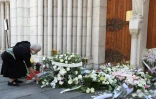 Une femme dépose des fleurs devant la basilique Notre-Dame à Nice en hommage aux victimes de l'attentat, le 30 octobre 2020 