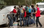 Des migrants de la "jungle" qui ont été sélectionnés s'apprêtent à monter dans un bus à destination d'un Centre d'accueil et d'orientation, le 13 septembre 2016 à Calais