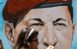 Une étudiante passe devant un portrait de l'ancien président vénézuélien Hugo Chavez, peint sur un mur, à Caracas le 29 janvier 2019
