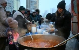 Des bénévoles de l'organisation caritative américaine World Central Kitchen distribuent un repas chaud aux habitants d'un quartier de Kiev, privé d'électricité et d'eau en raison de frappes russes, le 22 janvier 2026, en Ukraine