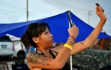 Une femme prend en photo un bourgeon de cannabis lors d'un festival célébrant la légalisation de cette drogue à Nakhon Pathom, en Thaïlande, le 11 juin 2022