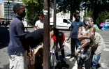 Des migrants se lavent près du campement installé sous la station de métro Jean Jaurès à Paris le 19 juillet 2016