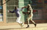 Un soldat zimbabwéen frappe un homme dans les rues de Harare, le 2 août 2018, après des manifestations contre des fraudes présumées lors des élections générales.