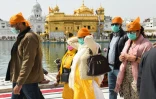 Des fidèles portant des masques de protection viennent prier au Temple d'Or d'Amritsar, édifice sacré des Sikhs, le 13 mars 2020 en Inde