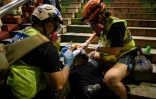 Un manifestant qui a reçu des gaz lacrymogènes est pris en charge par des secouristes volontaires lors des manifestation pro-démocratie, le 3 août 2019 à Hong Kong