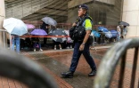 Un policier en patrouille devant la Cour de West Kowloon, à Hong Kong,  avant l'arrivée de Jimmy Lai pour son procès, le 18 août 2025