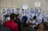 A l'extérieur de la morgue d'un hôpital de Damas, des personnes tentent d'identifier sur des photos de morts leurs proches disparus dans les prisons de l'ancien pouvoir syrien, le 12 décembre 2024