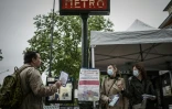 Des bénévoles distribuent des masques le 30 avril 2020 à l'extérieur d'une station de métro à Vincennes, en banlieue parisienne