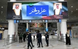 Des agents de sécurité koweïtiens sous un écran affichant les portraits de l'émir du Koweït, le cheikh Mech'al al-Ahmad al-Jaber al-Sabah (à droite), et du prince héritier koweïtien, le cheikh Sabah al-Khaled al-Hamad al-Sabah, accompagnés des mots "Fierté et Gloire", à l'aéroport international de Koweït City, le 1er juin 2026