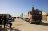 Des Palestiniens observent l'arrivée de camions transportant de l'aide humanitaire à Khan Younès, dans le sud de la bande de Gaza, après leur entrée par le côté égyptien du passage frontalier de Rafah, le 1er février 2026