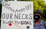 Walter Carter, 74 ans, venu de Gainesville, en Foride, porte une affiche "Enlevez votre genou de nos cous" pour une grande marche antiraciste à Washington le 28 août 2020