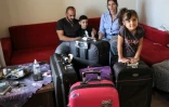 Nanor Abachian (2e d), son mari Shadi Abi Haidar, leur fille Scarlett (d) et leur fils Lucas (2e g) avec leurs bagages avant de partir pour Chypre, le 31 août 2021, chez eux, à Beyrouth
