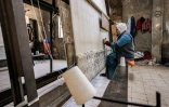 Une femme utilise un métier à tisser pour fabriquer un tapis dans un atelier de fabrication de tapis, dans un quartier du Caire, le 20 février 2023