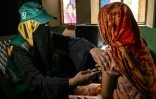 Une soignante (g) administre le vaccin contre le virus du papillome humain (VPH) à une adolescente, lors d'une campagne de vaccination contre le cancer du col de l'utérus, le 24 septembre 2025 à Karachi, au Pakistan