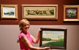 Antoinette Le Falher, directrice du musée d'Art Naïf et d'Arts Singuliers de Laval, pose le 29 août 2017 avec le tableau "Paysage avec pêcheur"