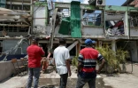 Des personnes regardent un bâtiment endommagé sur le site d'une explosion à la bombe survenue la veille à Cali, en Colombie, le 22 août 2025