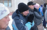 Des passants le 1er janvier 2019 à Magnitogorsk en Russie devant le site d'une explosion au gaz qui a ravagé un immeuble d'habitation