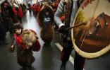 Des gens vêtus de peaux d'ours dans les rues de Comanesti, en Roumanie, le 30 décembre 2015