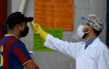 Un soignant vérifie la température d'un client dans un maché de Villa Nueva (Guatemala), le 20 juillet 2020