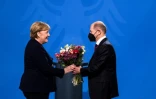 Le nouveau chancelier allemand Olaf Scholz remet un bouquet de fleurs à Angela Merkel lors de la passation de pouvoir à Berlin le 8 décembre 2021