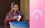 Une femme dépose son bulletin dans l'urne dans un bureau de vote lors des élections législatives népalaises à Katmandou, le 5 mars 2026