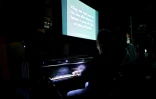 Des spectateurs assistent à la projection du film muet danois "The Mannequins" accompagnée d'une interprétation au piano, au musée du Cinéma à Londres, le 9 novembre 2024